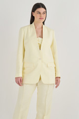 Profile view of model wearing the Oroton Collarless Blazer in Lemon Butter and 58% Viscose, 42% Linen for Women