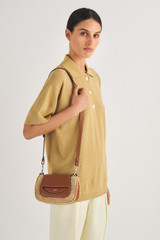 Profile view of model wearing the Oroton Haskin Texture Crossbody in Natural/Brandy and Raffia Straw Crochet With Leather Trims for Women