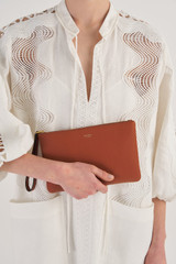 Profile view of model wearing the Oroton Eve Medium Pouch in Cognac and Pebble leather for Women