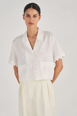 Profile view of model wearing the Oroton Cropped Scallop Camp Shirt in White and 100% Linen for Women