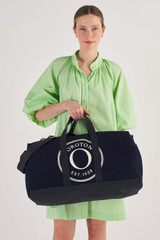 Profile view of model wearing the Oroton Kane Weekender in Navy and Recycled Canvas for Women