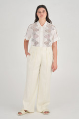Profile view of model wearing the Oroton High Waist Pleat Pant in Soft Cream and 100% Linen for Women