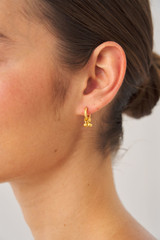 Profile view of model wearing the Oroton Como Hoops in Worn Gold and Brass base metal with precious metal plating for Women
