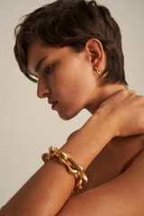 Profile view of model wearing the Oroton Eloise Small Huggies in Worn Gold and  for Women