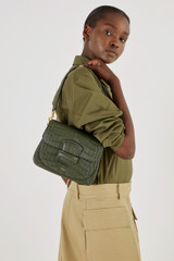 Profile view of model wearing the Oroton Carter Collectable Small Day Bag in Dark Moss and Textured Leather for Women