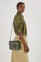 Profile view of model wearing the Oroton Carter Collectable Small Day Bag in Dark Moss and Textured Leather for Women