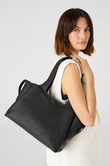 Profile view of model wearing the Oroton Alice Carry All in Black and Pebble Leather for Women