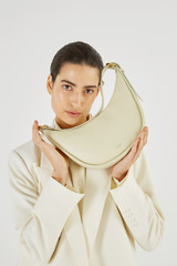 Profile view of model wearing the Oroton Penny Small Shoulder Bag in French Vanilla and Smooth Leather for Women