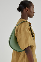 Profile view of model wearing the Oroton Penny Small Shoulder Bag in Shale Green and Smooth Leather for Women