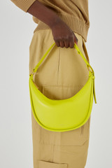 Profile view of model wearing the Oroton Penny Small Shoulder Bag in Bright Chartreuse and Smooth Leather for Women