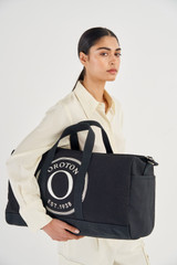 Profile view of model wearing the Oroton Kane Weekender in Black and Recycled Canvas for Women