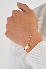 Profile view of model wearing the Oroton Nellie Pendant Bracelet in Gold/White and  for Women