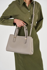 Profile view of model wearing the Oroton Anika Small Day Bag in Oyster and Pebble leather for Women