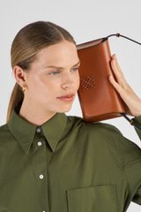 Profile view of model wearing the Oroton Della Small Baguette in Syrup and Smooth Leather for Women