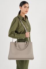 Profile view of model wearing the Oroton Anika 15" Day Bag in Oyster and Pebble leather for Women
