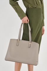 Profile view of model wearing the Oroton Anika 15" Day Bag in Oyster and Pebble leather for Women