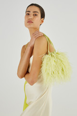 Profile view of model wearing the Oroton Grace Feather Bag in Citrine and Polyester Satin for Women