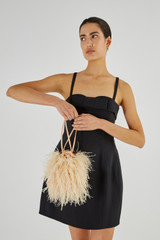 Profile view of model wearing the Oroton Grace Feather Bag in Peach Glow and Polyester Satin for Women