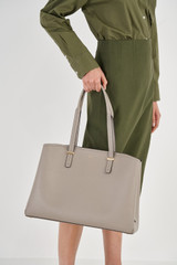 Profile view of model wearing the Oroton Anika 13" Day Bag in Oyster and Pebble leather for Women