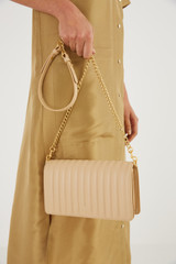 Profile view of model wearing the Oroton Fay Medium Chain Crossbody in Sand and Nappa Leather for Women