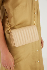 Profile view of model wearing the Oroton Fay Mini Chain Crossbody in Sand and Nappa Leather for Women
