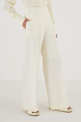 Profile view of model wearing the Oroton Flat Fronted Pant in Cream and 53% Polyester 43% Wool 4% Elastane for Women