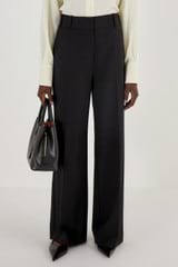 Profile view of model wearing the Oroton Flat Front Pant in Black and 53% polyester, 42% virgin wool, 5% elastane for Women