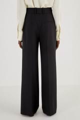 Profile view of model wearing the Oroton Flat Front Pant in Black and 53% Polyester 42% Wool 5% Elastane for Women
