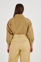 Profile view of model wearing the Oroton Silky Utility Shirt in Tobacco and 100% Silk for Women