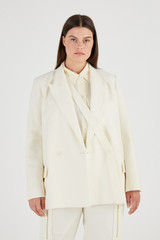 Profile view of model wearing the Oroton Double Breasted Blazer in Cream and 53% Polyester 43% Wool 4% Elastane for Women