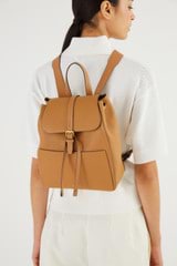 Profile view of model wearing the Oroton Dylan Medium Zip Buckle Backpack in Tan and Pebble Leather for Women