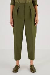 Profile view of model wearing the Oroton Pleat Curved Leg Pant in Khaki and 61% Cotton, 39% Polyester for Women