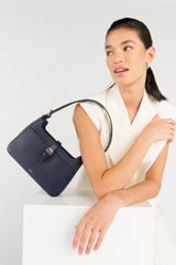 Profile view of model wearing the Oroton Dylan Baguette in Dark Navy and Pebble Leather for Women