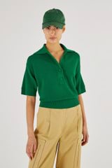 Profile view of model wearing the Oroton Mesh Stitch Polo in Kelly Green and 83% Viscose 17% Polyester for Women
