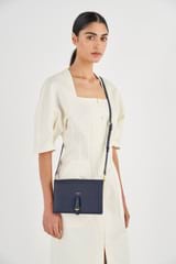Profile view of model wearing the Oroton Dylan Fold Over Crossbody in Dark Navy and Pebble Leather for Women