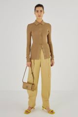 Profile view of model wearing the Oroton Long Sleeve Rib Cardi in Tobacco and 77% Viscose 23 % Polyester for Women
