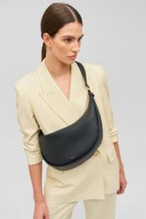 Profile view of model wearing the Oroton Penny Hobo in Black and Smooth leather for Women