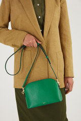 Profile view of model wearing the Oroton Inez Slim Crossbody in Emerald and Shiny Soft Saffiano for Women