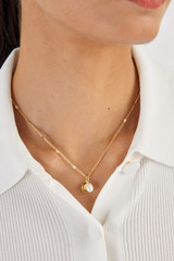 Profile view of model wearing the Oroton Nellie Pendant Necklace in Gold/White and  for Women