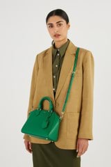 Profile view of model wearing the Oroton Inez Mini Day Bag in Emerald and Shiny Soft Saffiano for Women