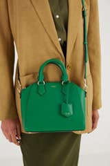 Profile view of model wearing the Oroton Inez Mini Day Bag in Emerald and Shiny Soft Saffiano for Women