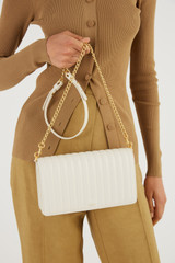 Profile view of model wearing the Oroton Fay Medium Chain Crossbody in Rich Cream and Nappa Leather for Women