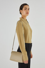 Profile view of model wearing the Oroton Alice Crossbody in Clay and Pebble Leather for Women
