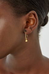 Profile view of model wearing the Oroton Jaclyn Drop Hoops in Worn Gold and  for Women