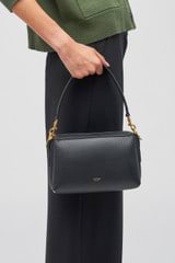 Profile view of model wearing the Oroton Alice Crossbody in Black and Pebble Leather for Women
