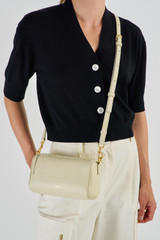 Profile view of model wearing the Oroton Thea Small Barrel Bag in French Vanilla and Smooth Leather for Women