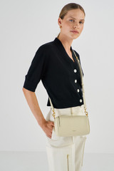 Profile view of model wearing the Oroton Thea Small Barrel Bag in French Vanilla and Smooth Leather for Women