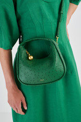 Profile view of model wearing the Oroton Clara Collectable Mini Bag in Kelly Green and Textured Leather for Women