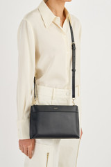 Profile view of model wearing the Oroton Harvey Double Zip Crossbody in Black and Smooth Leather for Women
