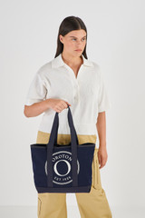 Profile view of model wearing the Oroton Kane Small Shopper Tote in Navy and Recycled Canvas for Women